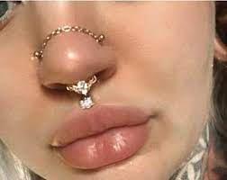 Two Nose Piercings On Each Side With Chain