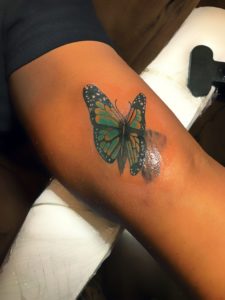 Blue Butterfly Tattoo On Dark Skin
