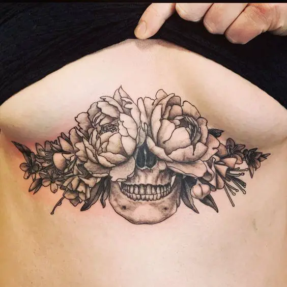 Skull And Flowers Under Chest Tattoo